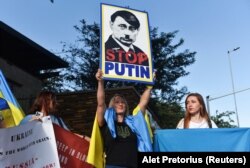 Акція на підтримку України під час візиту до Південно-Африканської Республіки глави МЗС Росії Сергія Лаврова. На плакаті зображення президента РФ Путіна в образі Гітлера. Преторія, 23 січня 2023 року