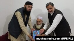 معذوریار (په منځ کې) خپله شعري ټولګه ملګرو ته ورکوي - پخوانی انځور.