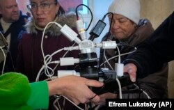 Люди в Херсоні заряджають свої телефони, намагаються підключитися до інтернету