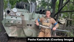 Український воїн із мечем на тлі захопленої внаслідок контрнаступу ЗСУ трофейної російської техніки. Харківщина, вересень 2022 року