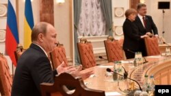 Під час переговорів у Мінську 11 лютого. На передньому плані президент Росії Володимир Путін. На задньому – президент України Петро Порошенко і канцлер Німеччини Анґела Меркель