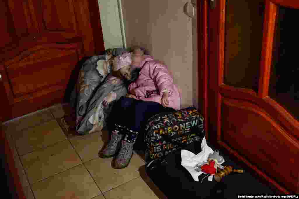 Дитина ховається в коридорі своєї квартири, пошкодженої під час ударів російських  «шахедів». У цей час ще триває повітряна тривога, за вікном чути роботу ППО