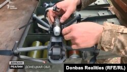 Дрон у процесі кріплення на нього осколкового пострілу – він призначений для скидання боєприпасу над ціллю