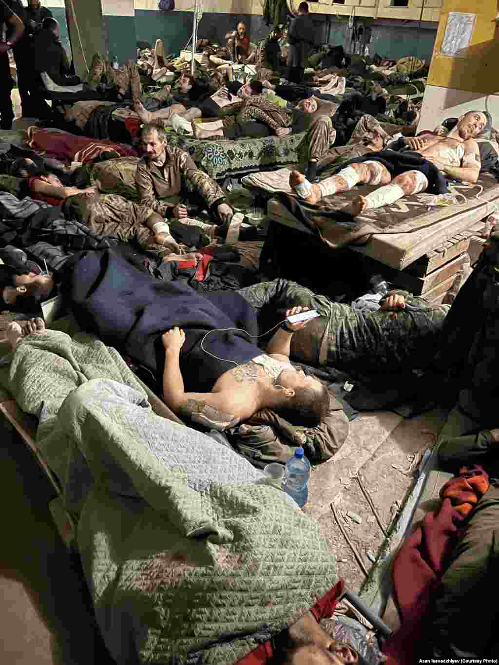Приміщення шпиталю на «Азовсталі». Асан Ісенаджиєв розповів, що кількасот поранених лежали «буквально один на одному». Їхній одяг був просочений кров’ю, на декого одягали речі загиблих бійців. Продовольства на всіх не вистачало: часом одну тарілку їжі доводилося ділити на кількох людей 