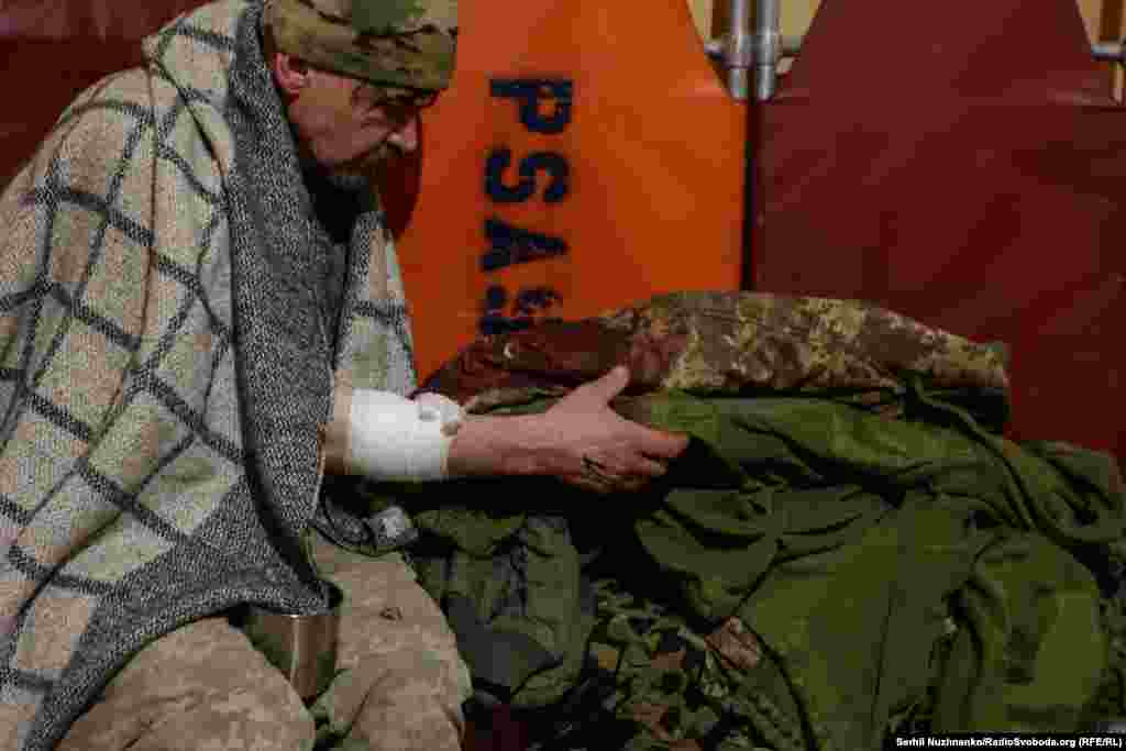 Поранений військовий оглядає свою просякнуту кров'ю форму в стабілізаційному пункті поблизу Авдіївського напрямку, березень 2024 року