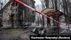 Частина російської ракети лежить на землі біля житлового будинку, пошкодженого внаслідок російського ракетного удару, 23 січня 2024 року