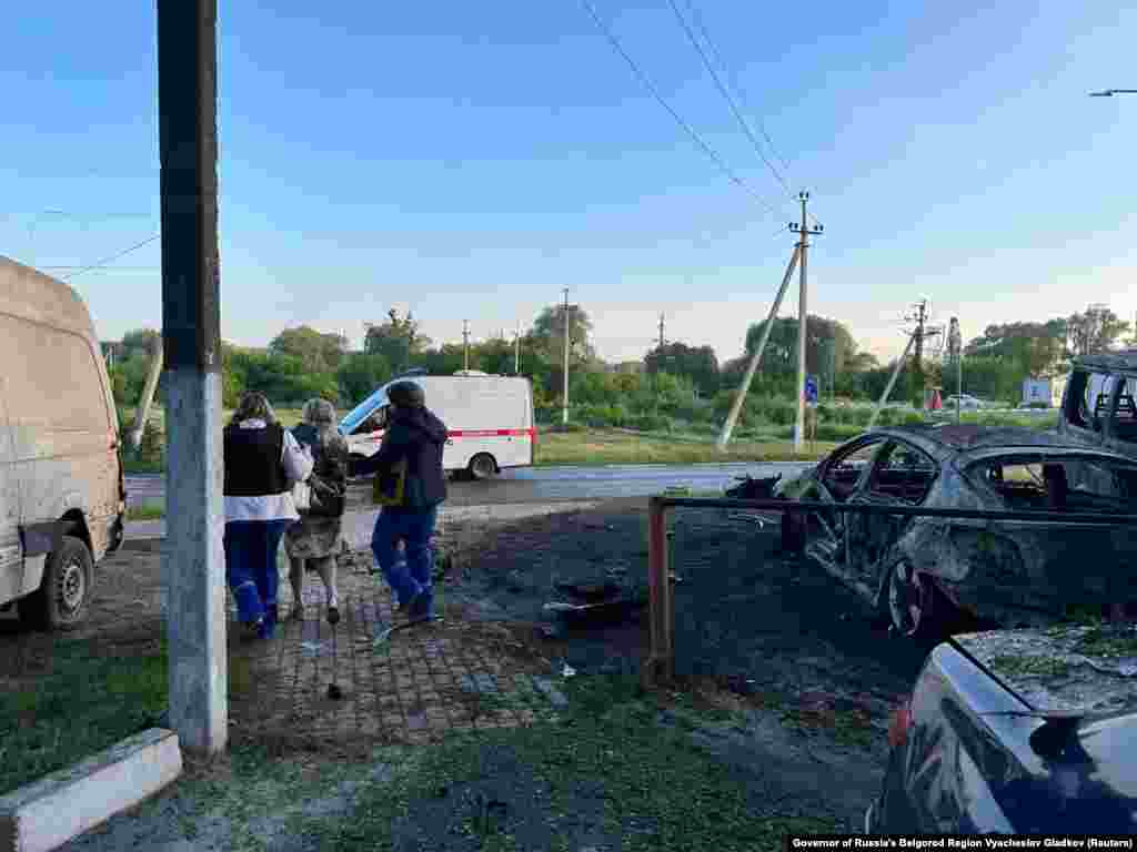 A woman is led away by two people wearing paramedic uniforms in Shebekino.  Gladkov said on Telegram that at 3:15 a.m. on May 31 "Grad shells" injured four people, with one man suffering serious wounds from shrapnel. RFE/RL is not able to verify the claims. 