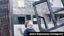 Трирічний Артем розглядає роботу, присвячену українським біженцям, які втратили дім