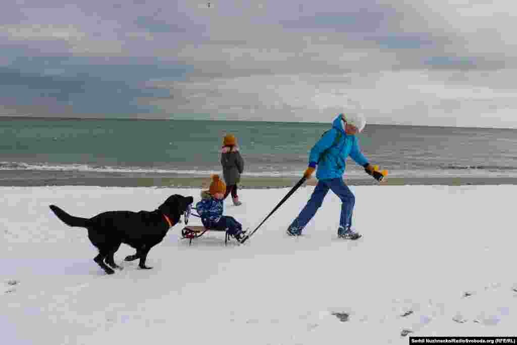 Одесити з маленькими дітьми вийшли кататись на санчатах на пляж «Ланжерон