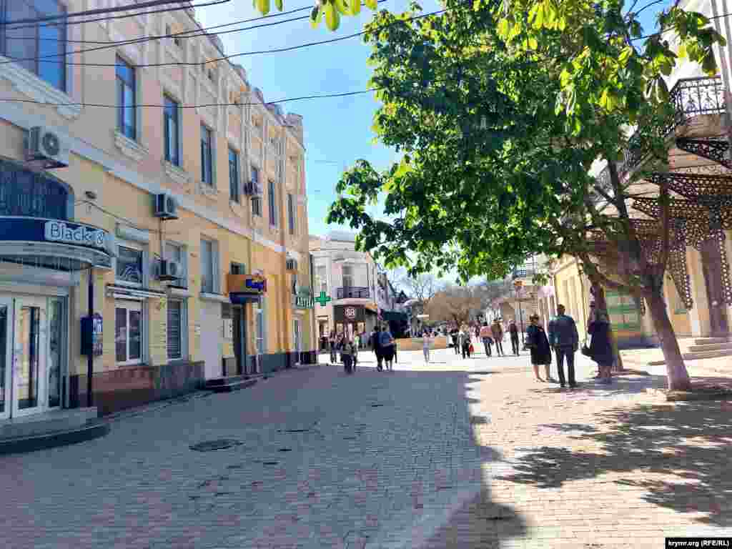 Цветущие каштаны отбрасывают кружевные тени на тротуар и дарят приятную прохладу