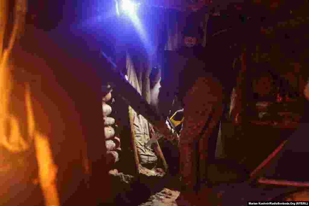 Коли фронт трішки стих, а погода погіршилася – солдати виходять назовні і шукають будматеріал – його можна знайти, адже ліс знищують російські снаряди. Після кожного обстрілу чути, які тріщать дерева і валяться додолу. Їх підбирають військові і намагаються укріпити бліндаж, щоб було тепліше та надійніше.  