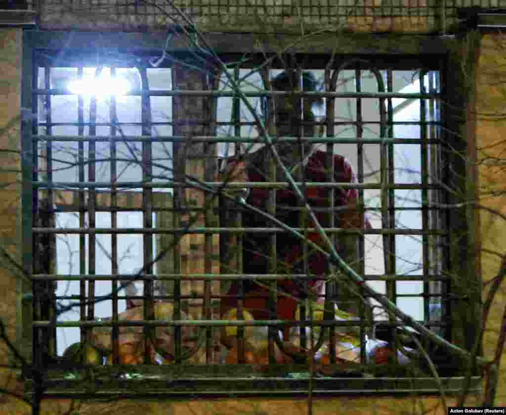 Навальный выглядывает из окна камеры в Москве в декабре 2011 года. Его приговорили к 15 суткам ареста за "сопротивление сотрудникам правоохранительных органов". Это было первое задержание оппозиционного политика.    