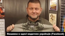 Головнокомандувач Збройних сил України Валерій Залужний тримає відтворену сорочку Степана Бандери. Сорочку за світлиною відтворив проєкт «Вишивка в одязі видатних українців» 