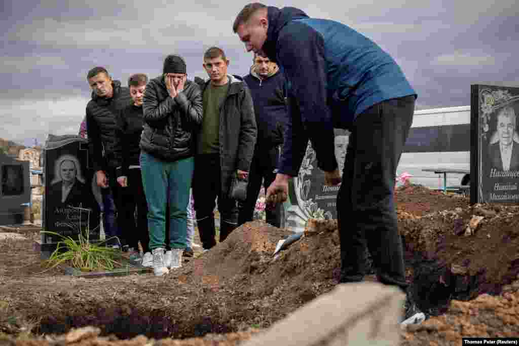 У селі Гроза Куп’янського району Харківщини цього тижня ховають тих, кого вдалося опізнати після російського ракетного удару 5 жовтня. На фото: рідні прощаються з 52-річною Тетяною Харбакою, Гроза, Куп'янський район, Харківська область, 9 жовтня 2023 року