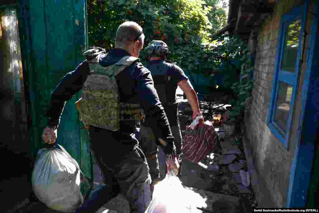 Сергій і Оуен швидко виносять речі: декілька пакетів з одягом. У цей час волонтери Даниїл й Анастасія готують своє авто для жінки, там – спеціальний матрац для маломобільних людей.