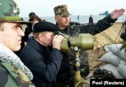 Президент України Леонід Кучма на острові Тузла дивиться на російську дамбу, спорудження якої здійснювали від Краснодарського краю Росії, 23 жовтня 2003 року