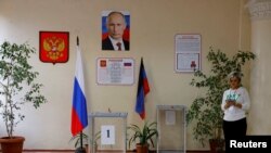 Posmatrač stoji pored glasačke kutije na biračkom mestu tokom lokalnih izbora koje su održale vlasti koje je postavila Rusija u Donjecku pod ruskom kontrolom u Ukrajini, 9. septembra 2023.