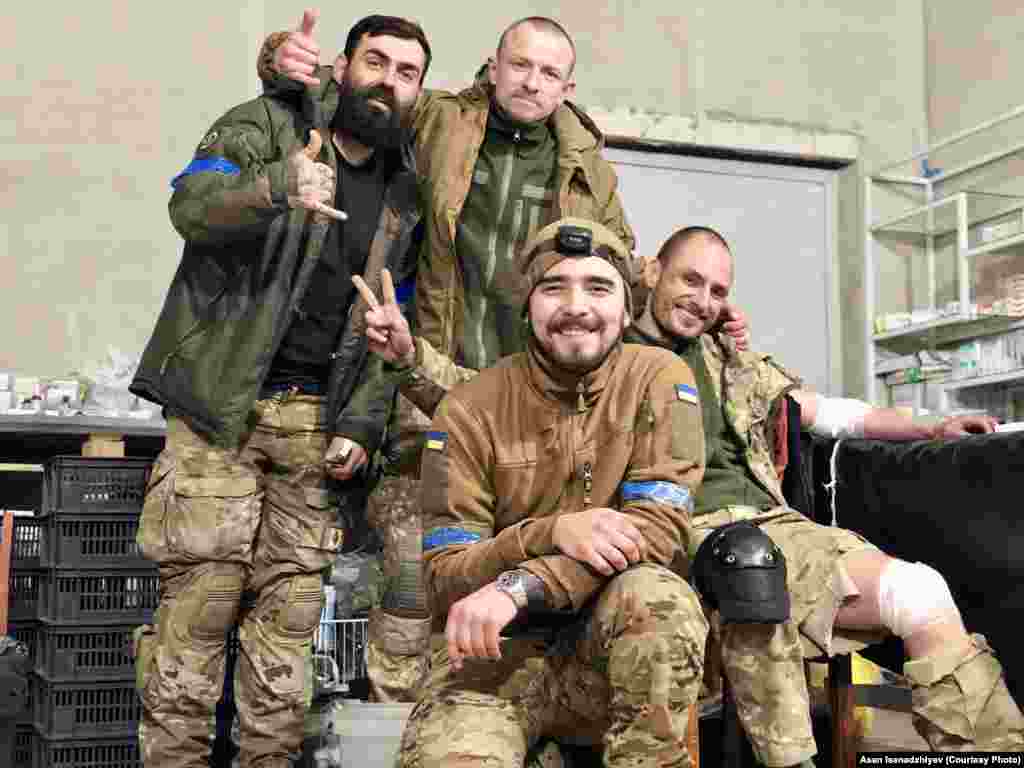 Маріуполь, 2022 рік. В центрі на цьому знімку – бойовий медик Асан Ісенаджиєв, який надав Радіо Свобода ці фотографії. Він вийшов з «Азовсталі» у травні 2022 року з останніми українськими підрозділами, що залишалися на оточеному заводі. Разом з іншими бійцями він був ув’язнений в колонії в Оленівці і вижив після підриву бараку з полоненими. 31 грудня 2022 року Асана обміняли. З ним на цій світлині позують бійці «Вишня», «Шпрот» та «Грян» (зліва направо). Вони прорвалися в оточений Маріуполь на гвинтокрилах. Із них трьох в живих залишився лише «Вишня» – він також пройшов російський полон, а після обміну повернувся у військо. «Шпрот» та «Грян» загинули в Маріуполі навесні 2022 року