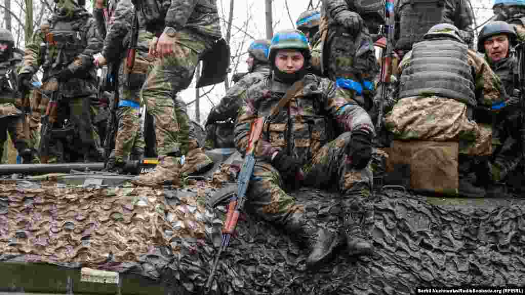 Бійці вантажаться на бронетехніку – БМП та танк – у повній бойовій готовності. Фото від 2 квітня 2022 року