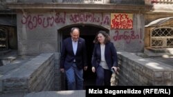 ევროკავშირის ელჩი საქართველოში პაველ ჰერჩინსკი საიას დირექტორ ნონა ქურდოვანიძესთან ერთად მას შემდეგ, რაც "აგენტების კანონის" მომხრეებმა ორგანიზაციის ოფისის შენობაზე შეურაცხმყოფელი წარწერები დატოვეს, 2024 წლის ივნისი