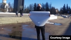 Михаил Гусев на антивоенной акции с плакатом без слов