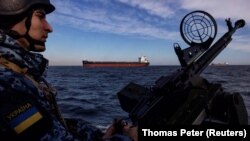 Військовослужбовець берегової охорони України на патрульному катері під час проходу вантажних суден у Чорному морі, 7 лютого 2024 року