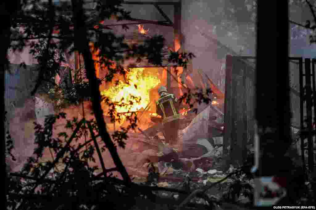 Пожежники гасять пожежу в одному з житлових районів Києва, яка виникла в результаті атаки російських військ 21 вересня 2022 року  