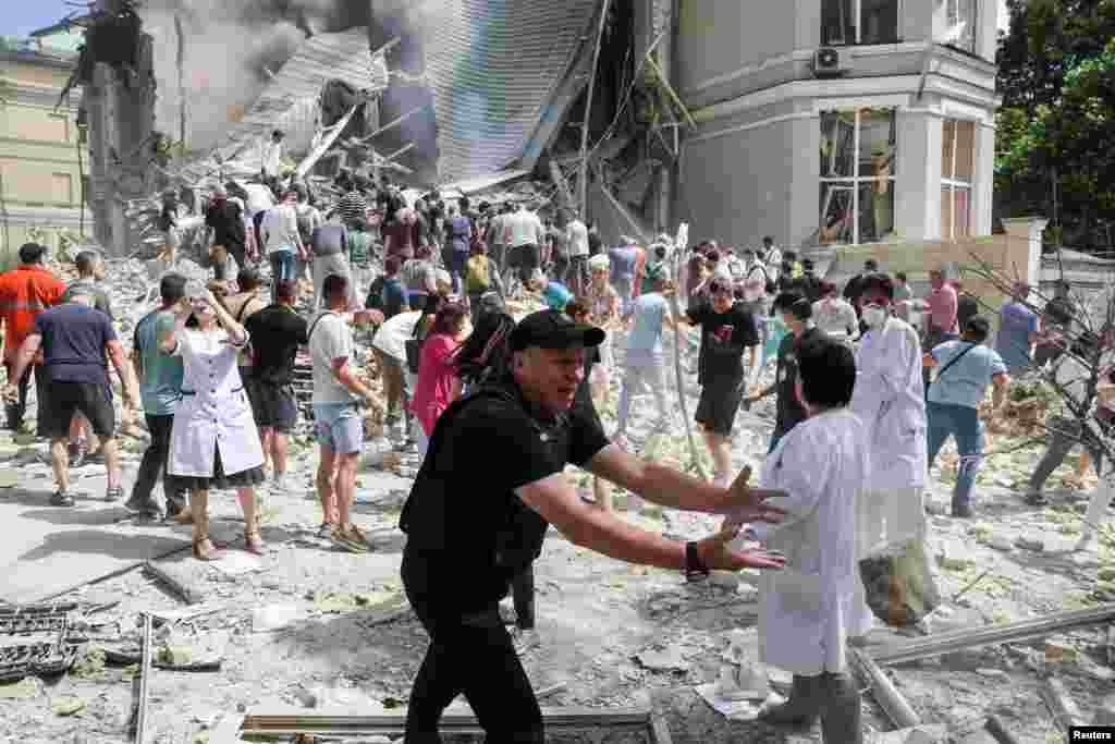 Люди, врачи и спасатели разбирают завалы одного из корпусов детской больницы "Охматдет" в Киеве, по которой российская армия нанесла удар, 8 июля 2024 года.