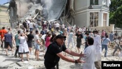 Люди допомагають розбирати завали в лікарні «Охматдит», яка сильно пошкоджена внаслідок атаки РФ, 8 липня 2024 року