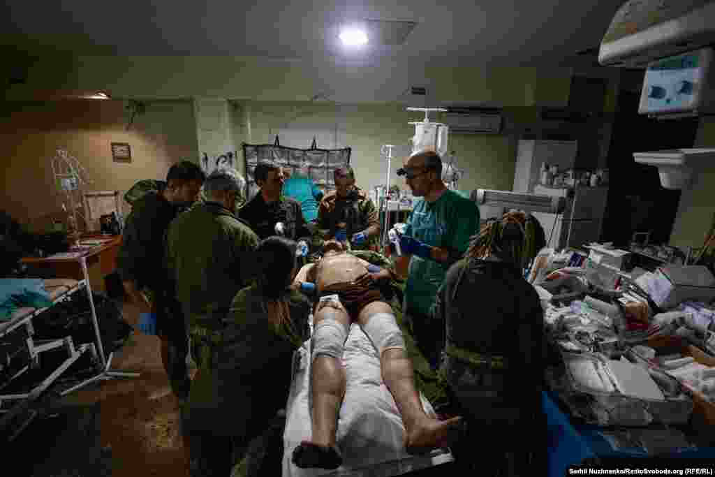 Військовий медик Дмитро Ксьондз каже: «Як і під час будь-якої хірургії, потрібно швидко зорієнтуватися і швидко стабілізувати (пацієнта – ред.).Стабілізувати дихання, крововтрату, тиск, пульс. Це по-перше. Далі – відправити на наступні етапи евакуації – там, де в більш спокійних умовах можуть надати спеціалізовану допомогу. Правильно відсортувати пацієнтів – легкий, середній або важкий – це те, що ми маємо зробити. Найголовніше – це скоротити перебування пацієнта, щоб середнє перебування «трьохсотого» (пораненого – ред.) у нас було мінімальним». Бахмутський стабпункт, листопад 2022 року 