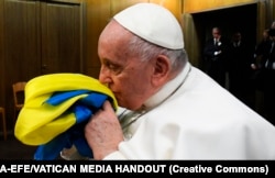 Папа Франциск целует украинский флаг. Ватикан, 24 февраля 2023 года, первая годовщина российского вторжения в Украину