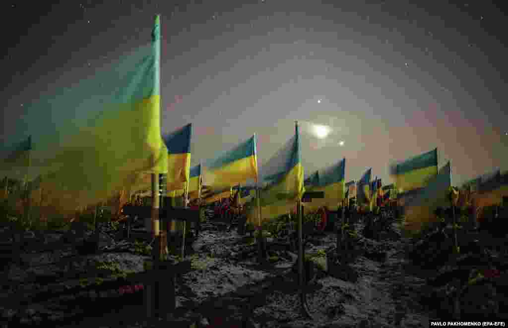 США кажуть, що втрати Росії у війні становлять не менше ніж 100 тисяч убитими та пораненими. Україна теж несе важкі втрати. Навколо українських міст розростаються військові цвинтарі. Українські прапори над могилами загиблих українських воїнів на військовому кладовищі в Харкові. 22 лютого 2023 року