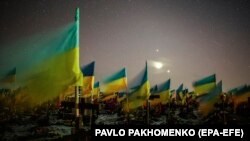 Українські прапори на могилах оборонців України, які загинули, відбиваючи агресію Росії. Одне із військових кладовищ під Харковим.