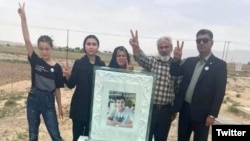 The family of Abolfazl Adinezadeh, a 17-year-old protester shot dead by Iranian security forces in October, stand by his grave on June 16.