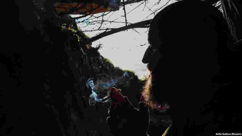 Український військовослужбовець 3-ї окремої десантно-штурмової бригади ЗСУ курить в укритті на передовій неподалік від Бахмуту, 23 квітня 2023 року. Багато експертів говорять, а українські лідери натякають, що Київ стоїть на порозі довгоочікуваної контратаки  