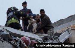 Співробітники служби надзвичайних ситуацій і волонтери рятують дитину після удару армії РФ по житловому багатоповерховому будинку в Слов’янську на Донеччині, 14 квітня 2023 року