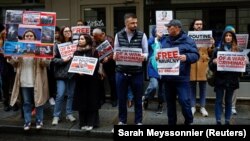 Протестувальники на акції біля будинку Світлани Маніович, дружини заступника міністра оборони Росії Тимура Іванова, закликають ЄС запровадити санкції проти неї та видворити її із Франції. Париж, 23 квітня 2023 року