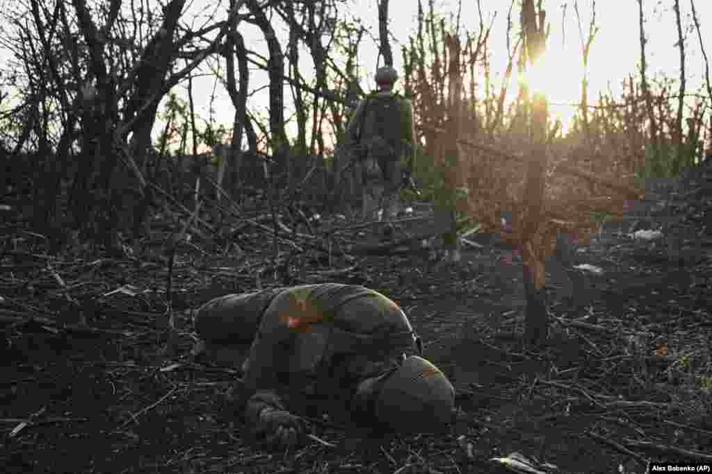 Український військовий проходить повз тіло загиблого російського військового біля Андріївки, 16 вересня 2023 року. Захоплення зруйнованого міста Бахмуту після місяців кровопролитних боїв Кремль на той час вважав «головною перемогою»  