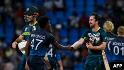 د اسټرالیا بیټران تر سیالۍ ګټلو وروسته د نمېبیا لوبغاړو ته لاس ورکوي - د جون ۱۲مې انځور.