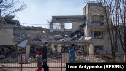 Жителі Херсона біля Херсонської академії неперервної освіти, зруйнованої російськими ударними БПЛА, березень 2024 року