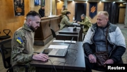 Dobrovoljac koji se nada da će ući u ukrajinsku 3. odvojenu jurišnu brigadu razgovara sa oficirima u regrutnoj kancelariji, 9. januar 2024.