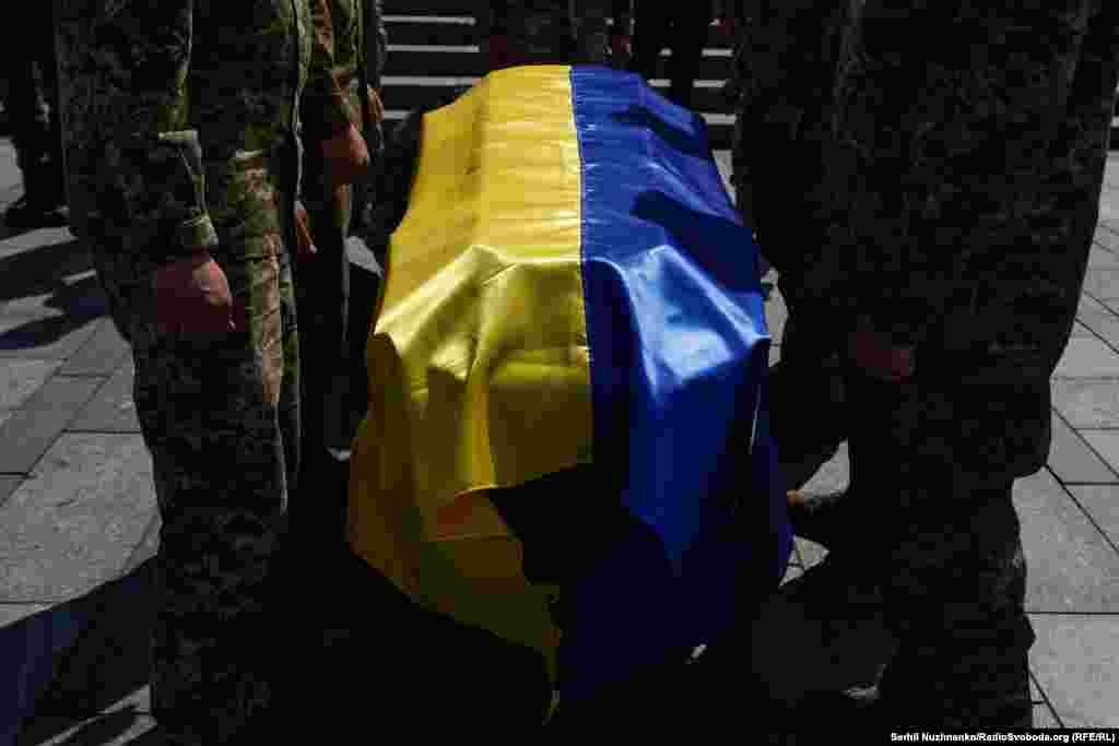 Державний прапор на труні героя. Прощання на Майдані Незалежності у Києві із Юрієм Морозом – молодшим сержантом Сил ТрО ЗСУ, членом Спілки Української Молоді в Україні, учасником Революції Гідності у складі 4 козацької сотні Самооборони Майдану, інструктором Всеукраїнської дитячо-юнацької патріотичної гри «Сокіл» («Джура»), військово-історичним реконструктором Армії УНР, УСС та УПА. Квітень 2023 року