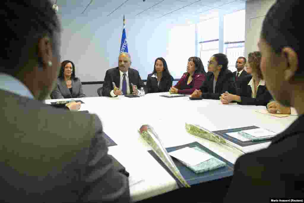 Тогдашний министр юстиции США Эрик Холдер (в центре) и прокурор Калифорнии Камала Харрис (слева) поздравляют выпускников одной из учебных программ для судей в окружном суде Лос-Анджелеса. 24 октября 2014 года  