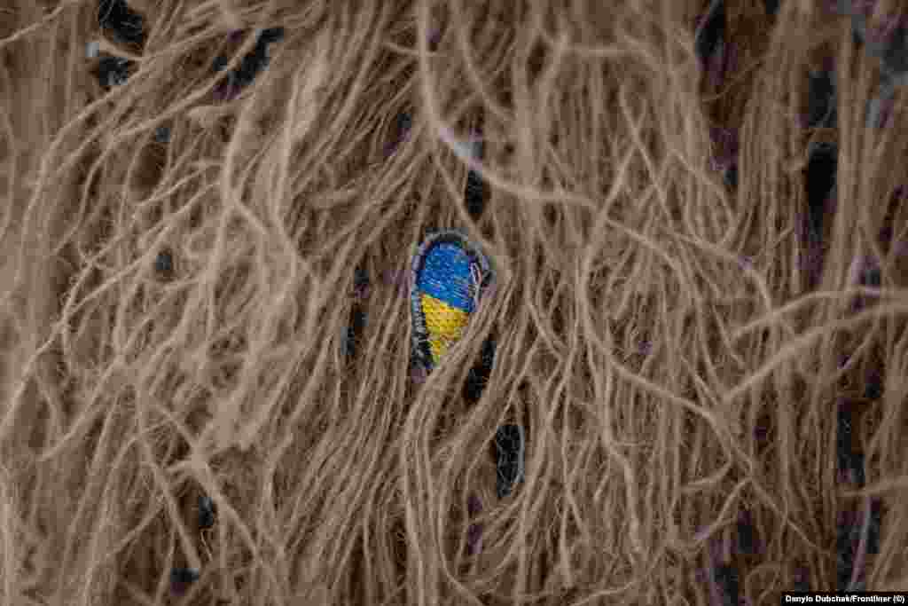 Маленька нашивка з українським прапором, захована всередині кікімори. Катерина служить в українській армії вже понад п'ять років, проте не планує залишатися у війську після перемоги України. «Я хочу подорожувати по світу, хотіла б ще раз поїхати в Іспанію, Фінляндію, Америку», – каже вона. Найважче, за її словами, визнати той факт, що війна, яку розпочала Росія, навряд чи закінчиться найближчим часом. «Ти робиш великий вклад у це і ти не розумієш, де межа, і чи ти взагалі доживеш до цієї межі», – каже вона. Ця фотогалерея є адаптованою версією репортажу Олени Максименко та Данило Дубчака, яку вперше опублікував Frontlineer