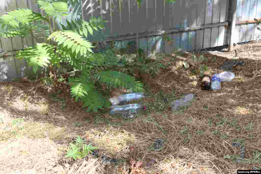 По другую сторону забора – мусор и бутылки из-под пива у подножия исторического сооружения