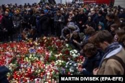 Люди вшановують пам'ять загиблих і висловлюють співчуття їхнім родинам. Перед головним корпусом університету в центрі Праги, Чеська Республіка, 22 грудня 2023 року.