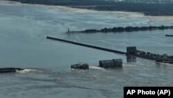 Зруйнована ГЕС і греблю Каховського водосховища. Фото від 8 червня 2023 року. Ще в жовтні 2022 року працівники ГЕС повідомляли, що російські військові замінували машинну залу гідроелектростанції. Російська армія контролювала дамбу і ГЕС із лютого 2022 року