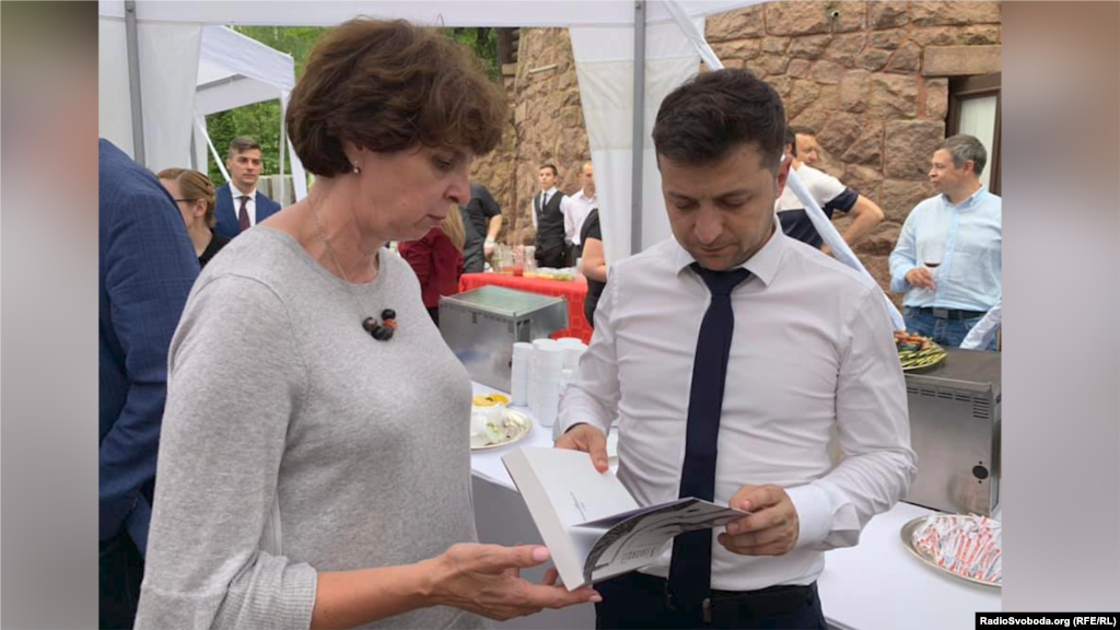 Інна Кузнецова передає президентові України Володимиру Зеленському книгу «В ізоляції. Есеї про Донбас» Станіслава Асєєва, який на той час перебував у полоні вже два роки, червень 2019 року