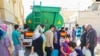 Tehran residents line up for water on June 13. 