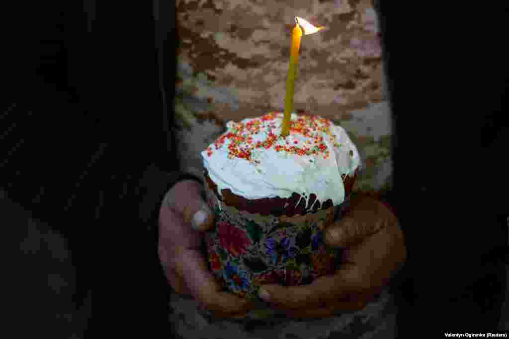 Український військовий 93-ї ОМБр тримає паску під час великоднього богослужіння поблизу лінії фронту